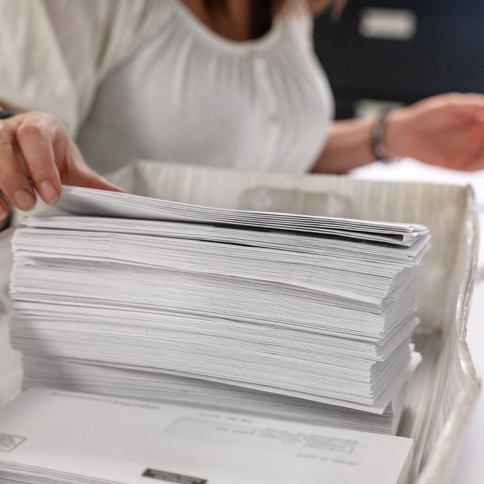 A hand grabs mail from a basket