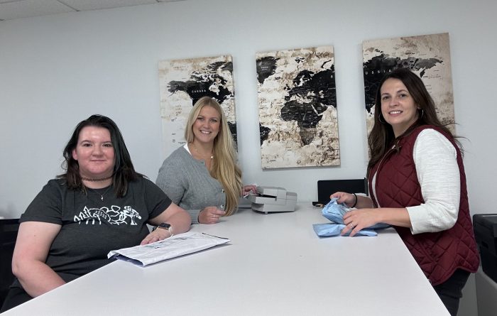 Three employees of Illinois Registered Office gather at a table at our office in Springfield.