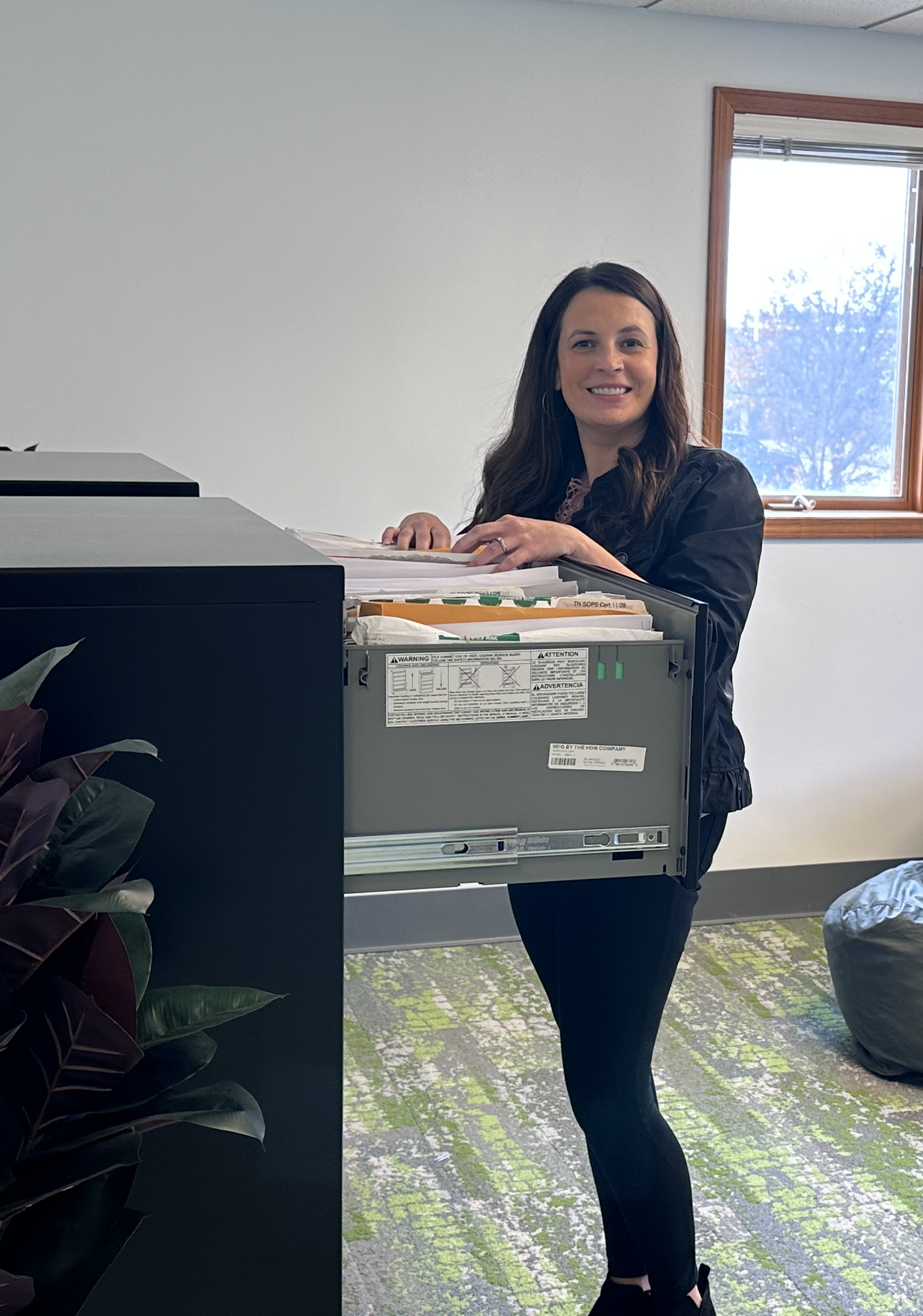 A registered agent at Illinois Registered Office putting a document in a filing cabinet.